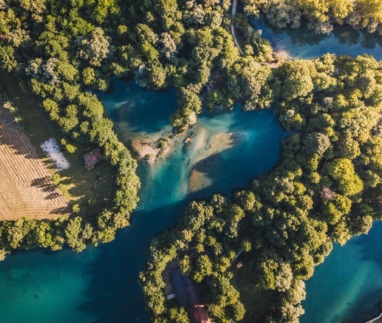 luchtfoto van de kronkelende Una-rivier met turquoise water en beboste oevers in Bosnië en Herzegovina
