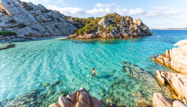 Vrouw zwemt in zee bij Cala Napoletana, Caprera, La Maddalena Archipelago Nationaal Park, Sardinië