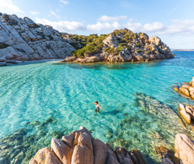 Vrouw zwemt in zee bij Cala Napoletana, Caprera, La Maddalena Archipelago Nationaal Park, Sardinië