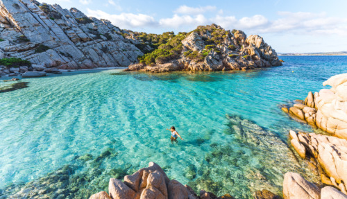 Vrouw zwemt in zee bij Cala Napoletana, Caprera, La Maddalena Archipelago Nationaal Park, Sardinië