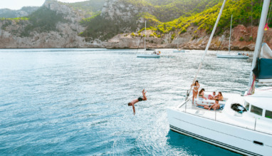 Vrienden duiken van een catamaran af in de Balearen, Spanje
