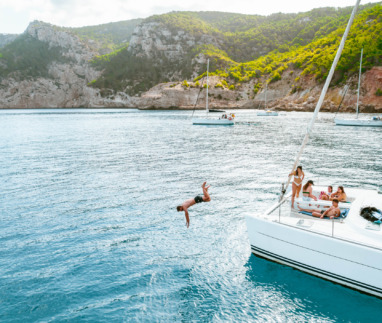 Vrienden duiken van een catamaran af in de Balearen, Spanje