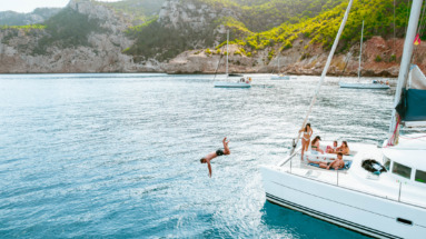 Vrienden duiken van een catamaran af in de Balearen, Spanje