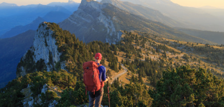 Hiker kijkt uit over de bergen van Vercors, Frankrijk tijdens zonsondergang