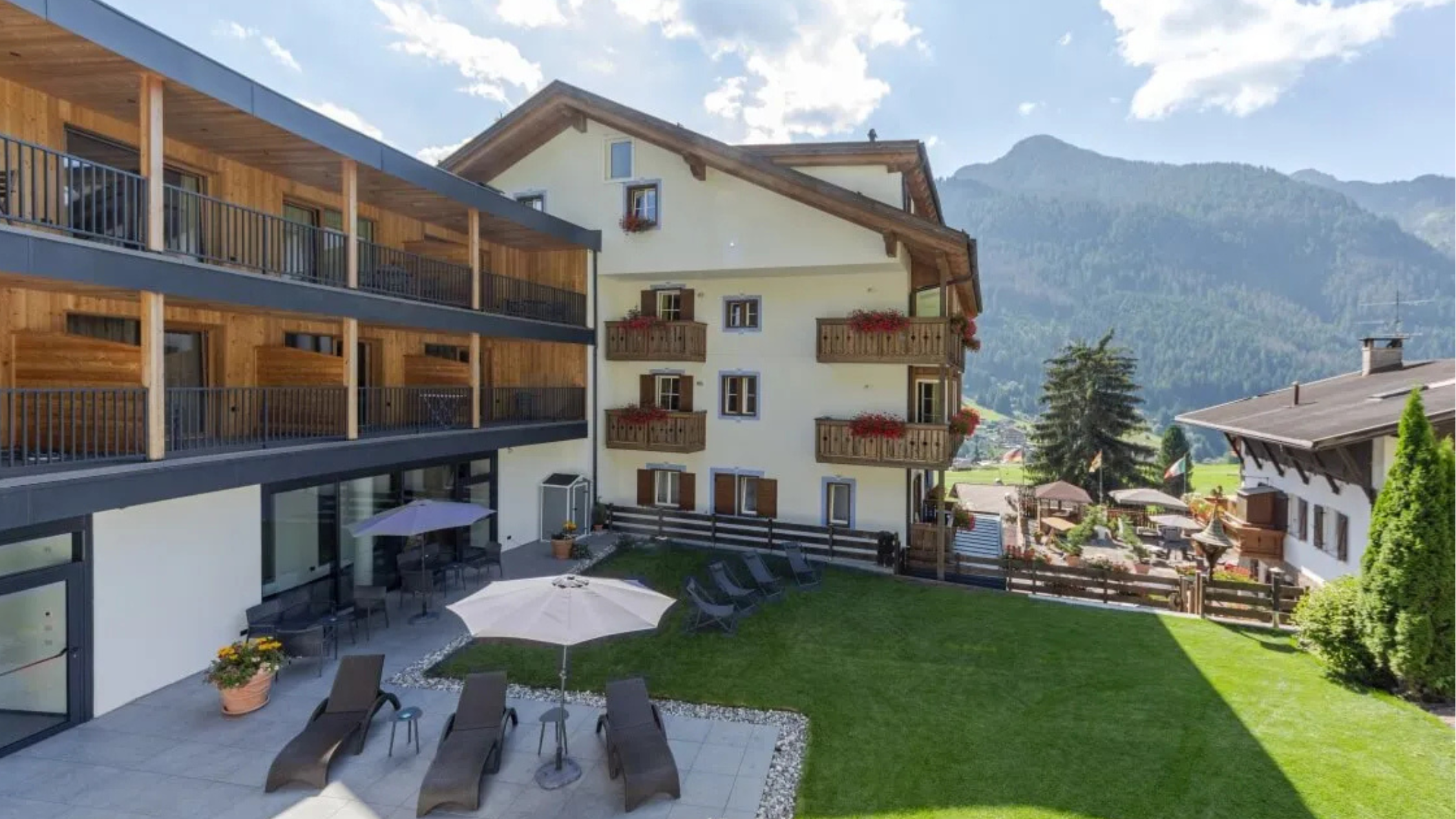 hotel met tuin en ligstoelen tegen berglandschap in Trentino