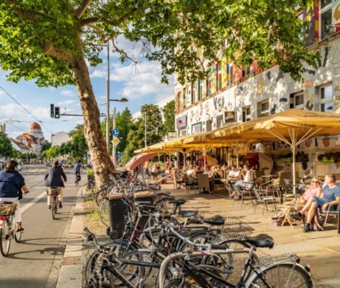 Levendig straatbeeld in de wijk Südvorstadt met kleurrijke gevels, fietspaden en gezellige terrassen.