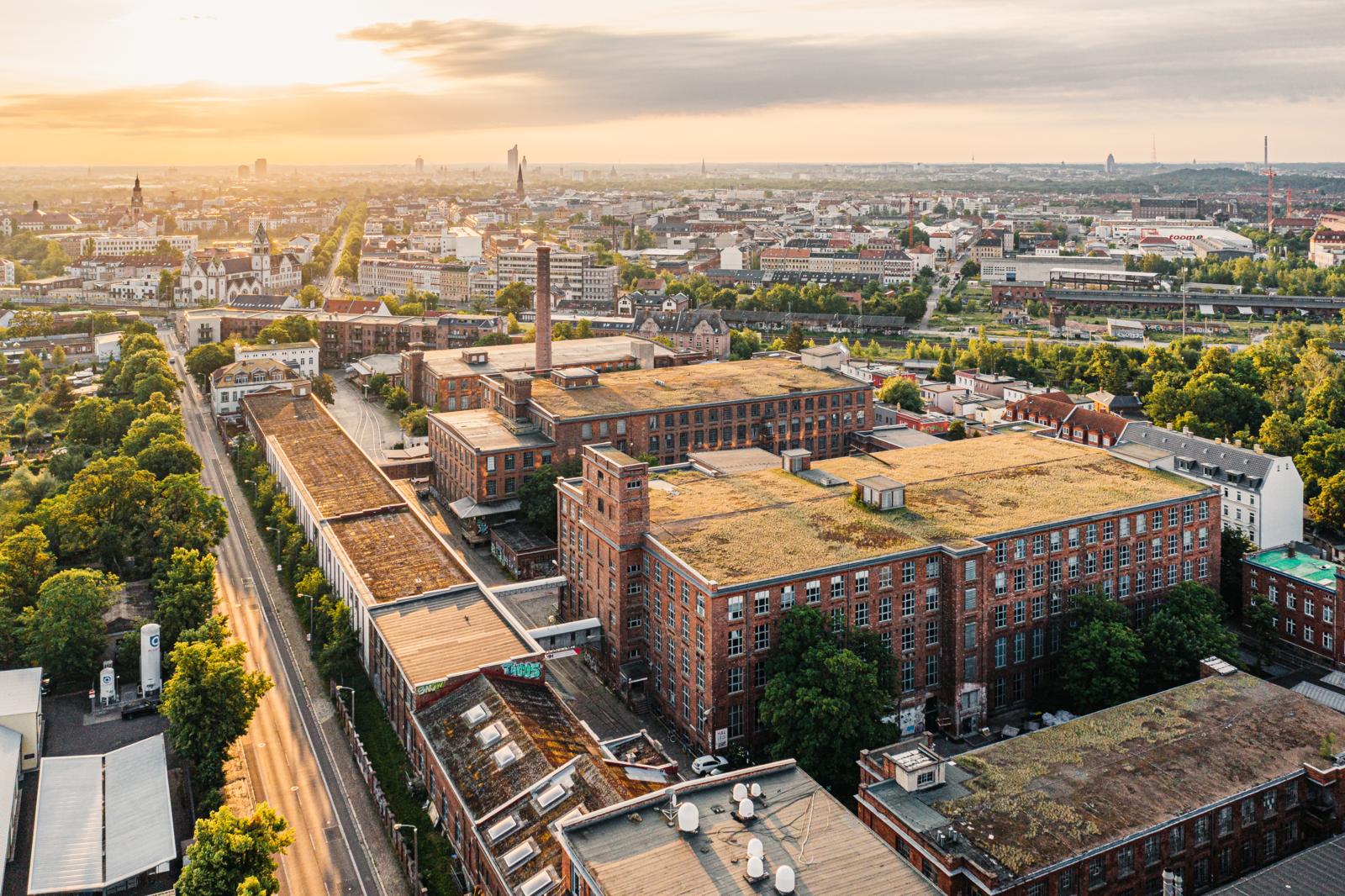 Luchtfoto van de historische bakstenen fabrieksgebouwen van de Baumwollspinnerei in de wijk Lindenau, Leipzig.