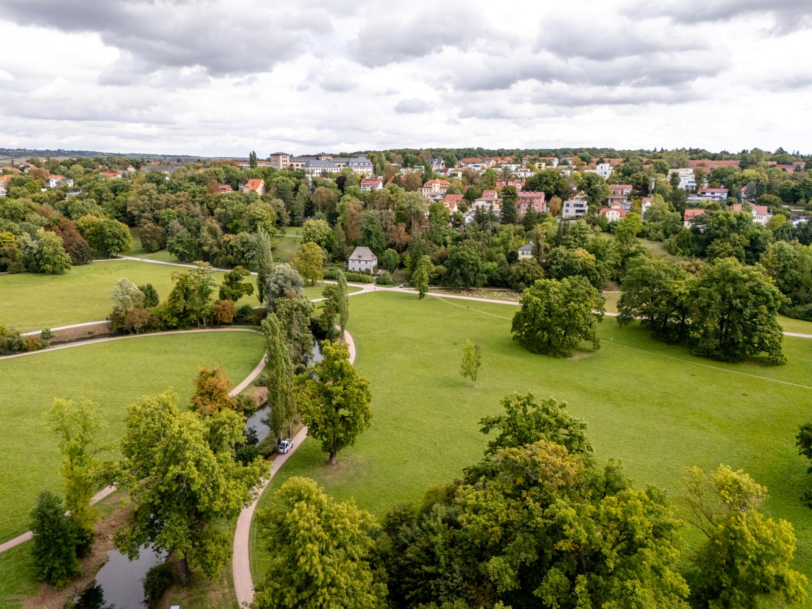 Luchtfoto van het uitgestrekte Park an der Ilm met wandelpaden, bomen en historische gebouwen in Weimar.