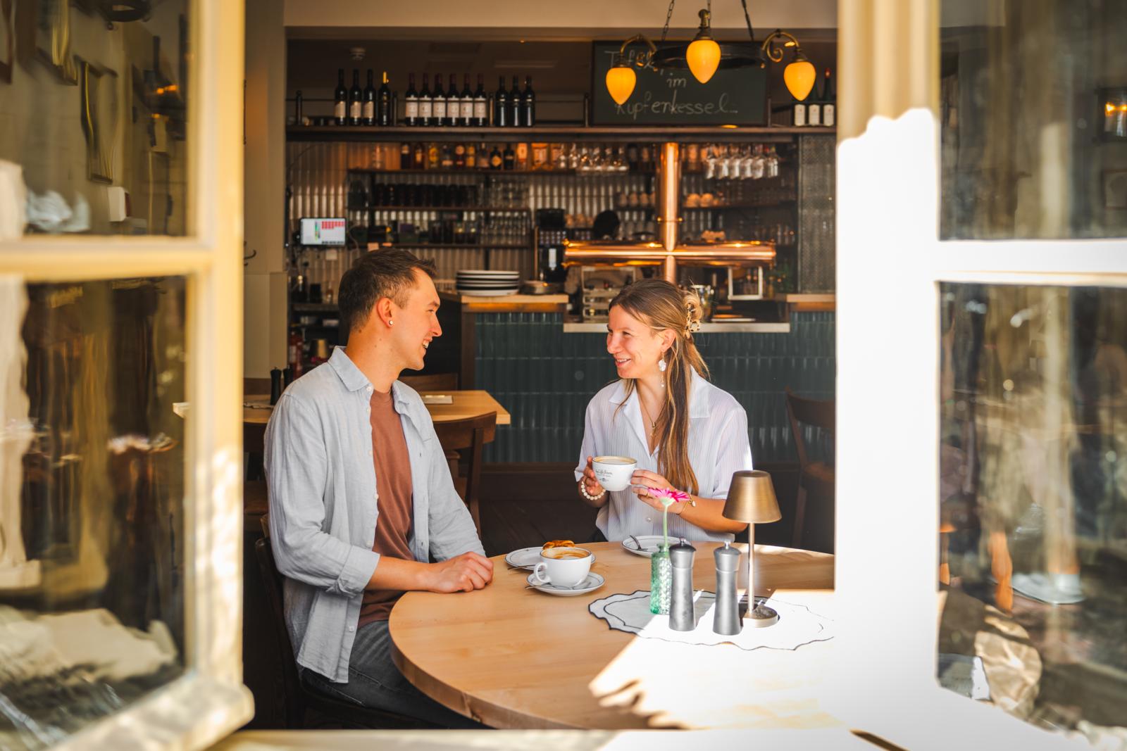 Een man en vrouw genieten van koffie aan een ronde tafel in het historische café Zum Arabischen Coffe Baum.