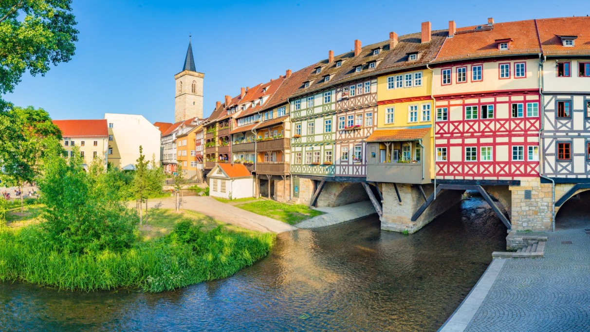 Panoramisch uitzicht op de bewoonde Krämerbrücke met vakwerkhuizen en de Aegidienkirche-toren in Erfurt.