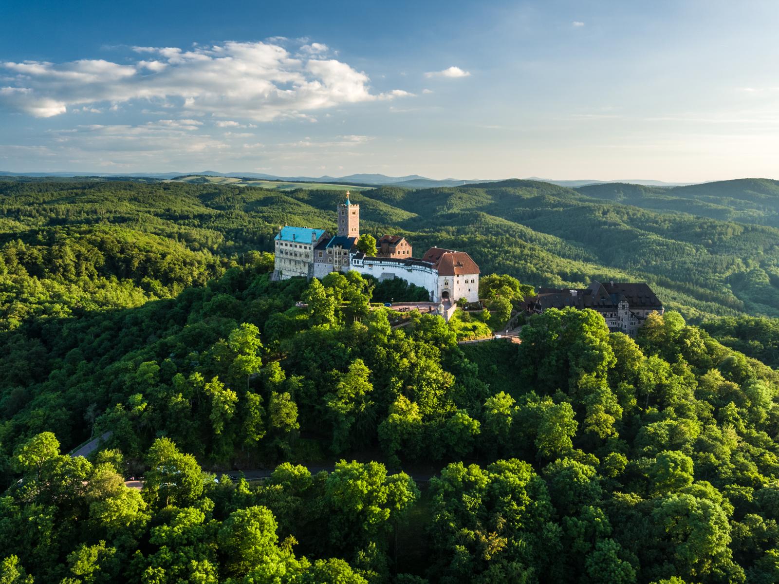 Luchtfoto van de middeleeuwse Wartburg op een bergtop midden in het dichte groene Thüringer Woud.
