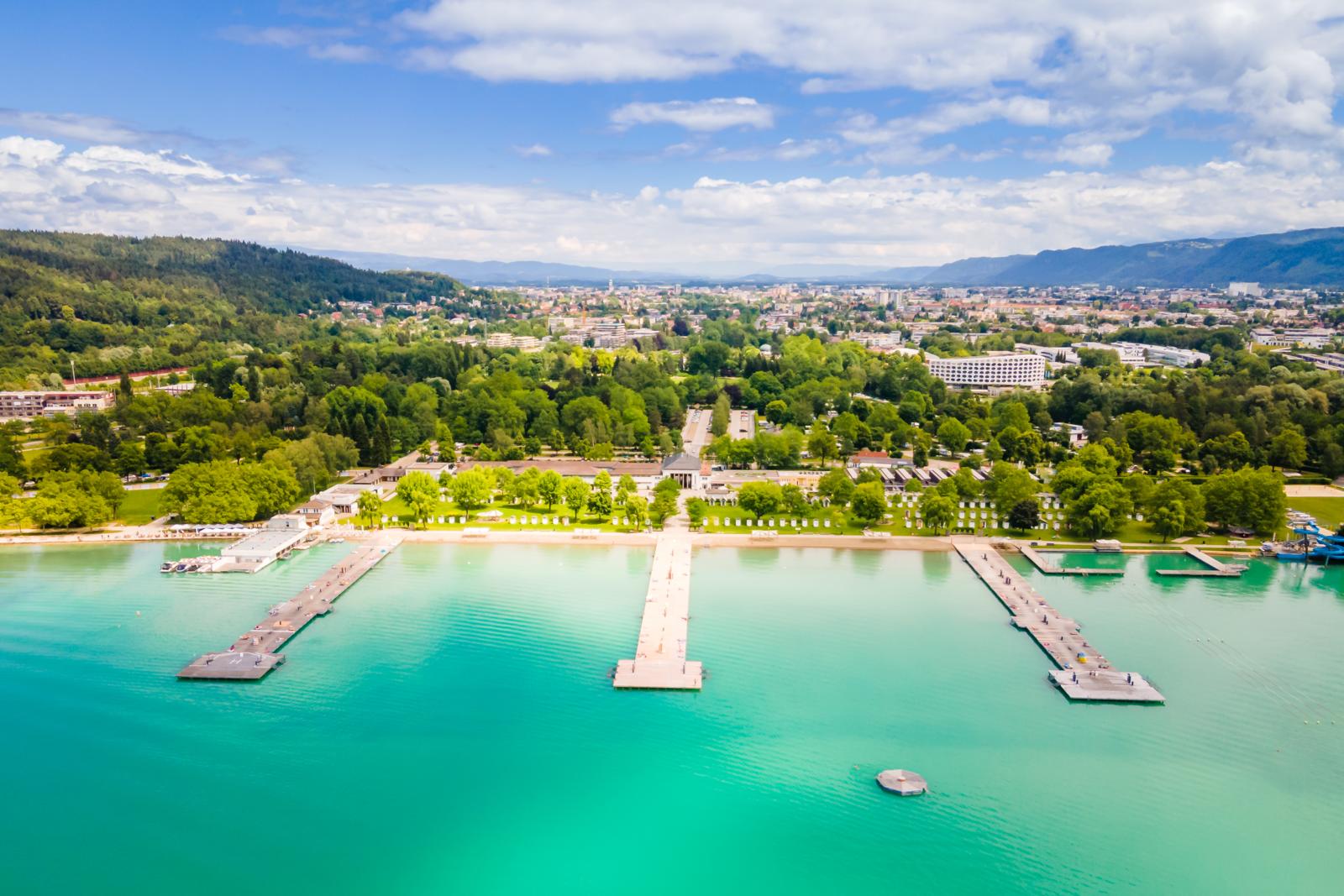 Een luchtfoto van het grote, zonnige strandbad in Klagenfurt aan de turquoise oevers van de Wörthersee in Oostenrijk.