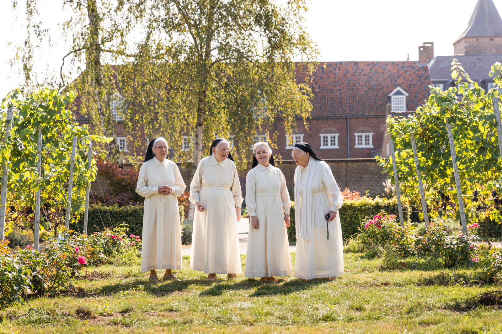 Nonnen in de zonnige moestuin van het historische klooster Sint-Catharinadal.