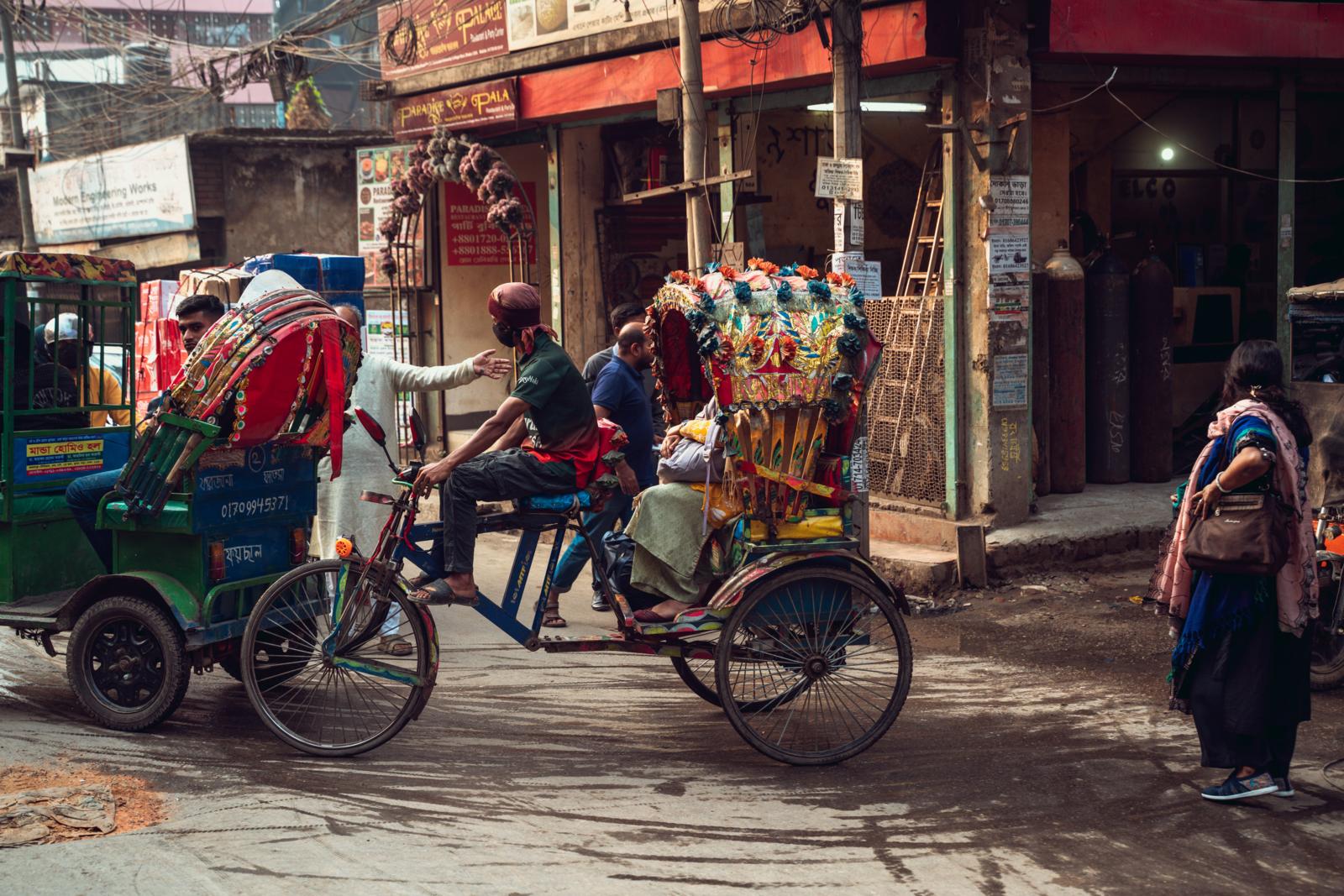 kleurrijke fietsriksja’s in een drukke straat in Dhaka, Bangladesh