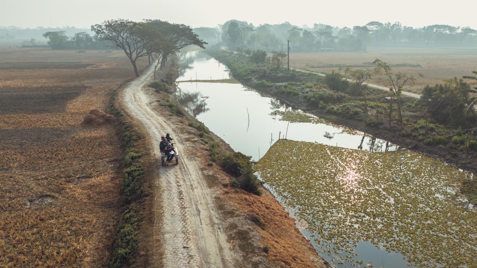 landweg langs waterkanaal en akkers nabij de Sundarbans in Bangladesh
