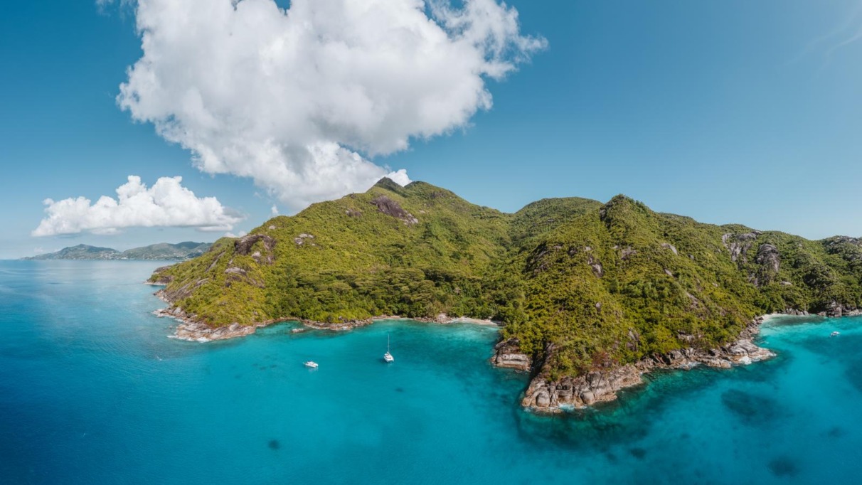 Luchtfoto van de turquoise baai en groene heuvels rond Anse Major op Mahé in de Seychellen