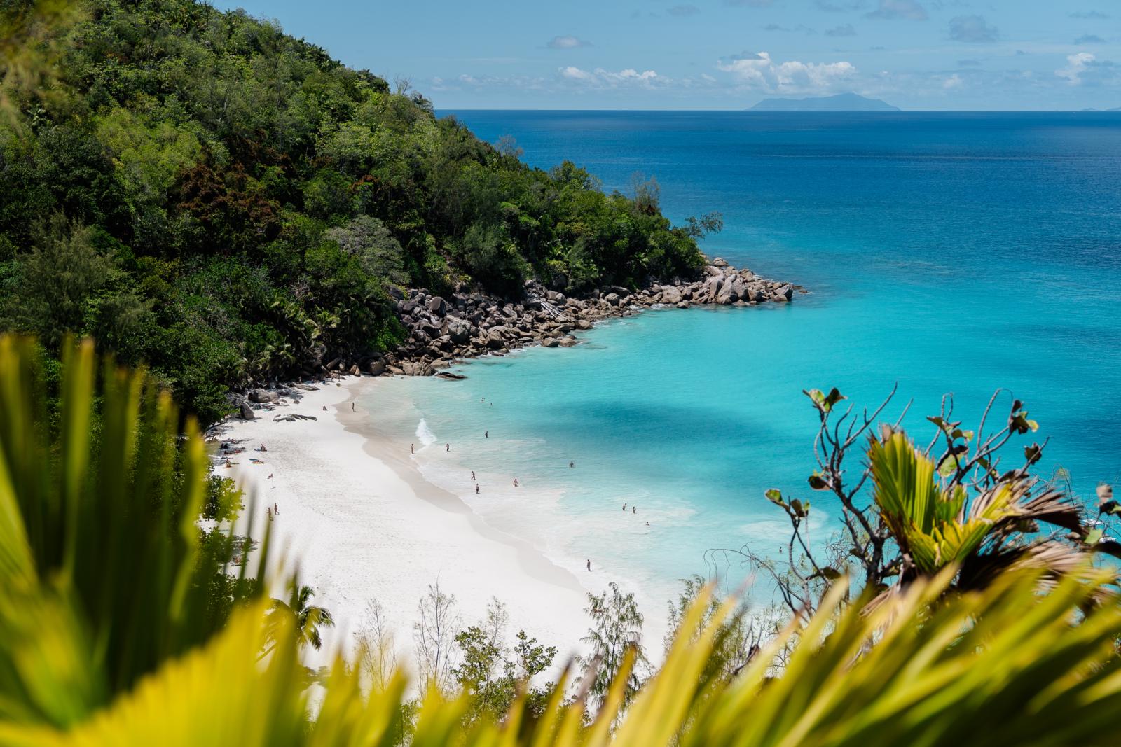 Uitzicht op het witte zandstrand en turquoise water van Anse Georgette op het eiland Praslin in de Seychellen