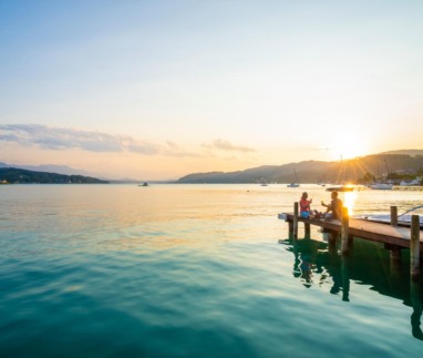 Stel geniet van de ondergaande zon bij de Wöthersee in Karinthië