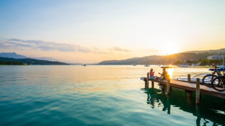 Stel geniet van de ondergaande zon bij de Wöthersee in Karinthië