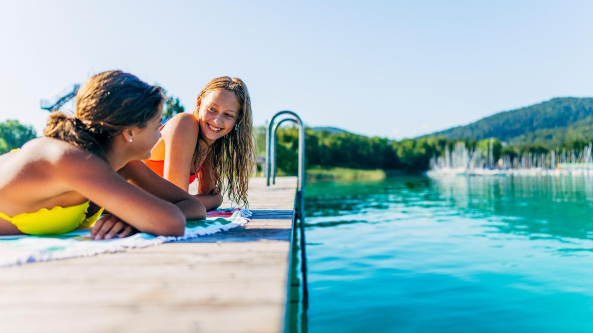 Twee meisjes relaxen op een steiger aan de Wörthersee in Oostenrijk
