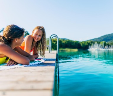 Twee meisjes relaxen op een steiger aan de Wörthersee in Oostenrijk