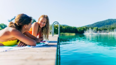 Twee meisjes relaxen op een steiger aan de Wörthersee in Oostenrijk