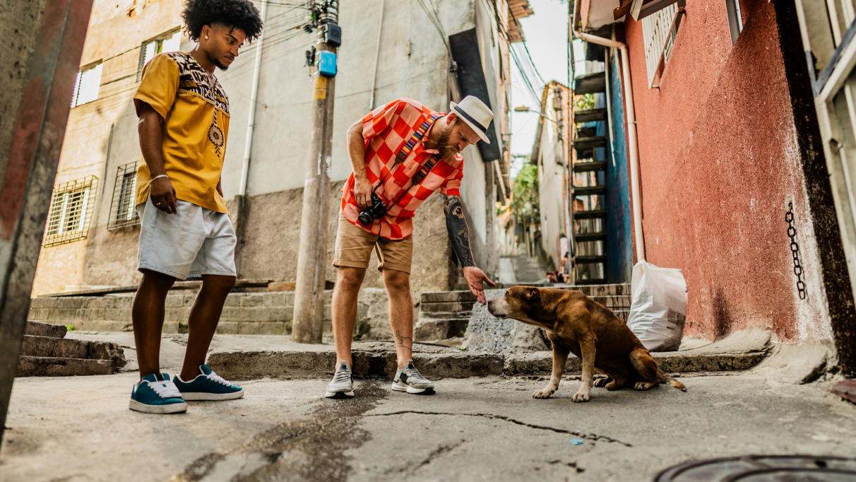 Tourists friends with dog from street in a favela, Brazil