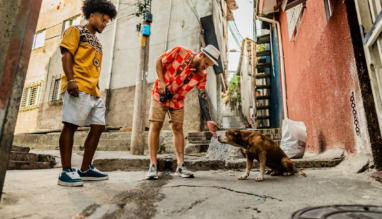 Tourists friends with dog from street in a favela, Brazil