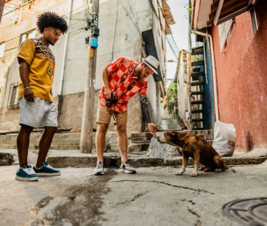 Tourists friends with dog from street in a favela, Brazil