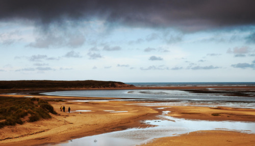 Panoramisch uitzicht over de kreken en duinen van natuurgebied De Slufter op Texel onder een dreigende lucht.