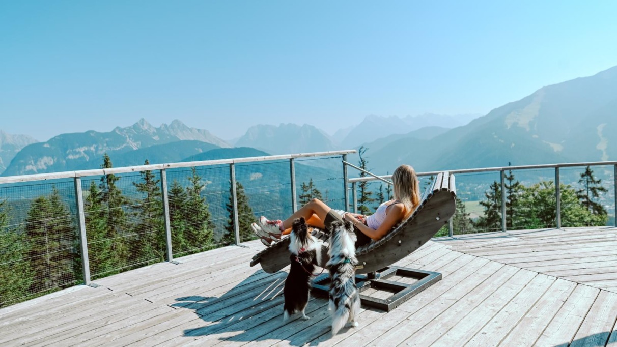 Vrouw ontspant met honden met uitzicht over Seefeld in Oostenrijk