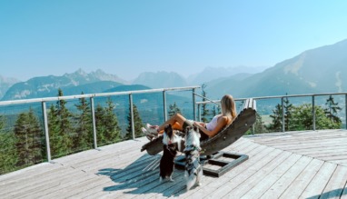 Vrouw ontspant met honden met uitzicht over Seefeld in Oostenrijk