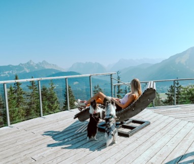 Vrouw ontspant met honden met uitzicht over Seefeld in Oostenrijk