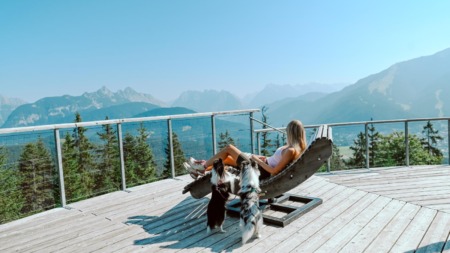Vrouw ontspant met honden met uitzicht over Seefeld in Oostenrijk