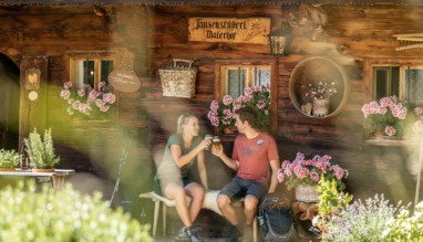 Stelletje rust bij een berghut in het Alpbachtal in Oostenrijk en proost met een biertje