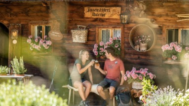 Stelletje rust bij een berghut in het Alpbachtal in Oostenrijk en proost met een biertje