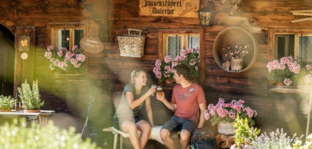 Stelletje rust bij een berghut in het Alpbachtal in Oostenrijk en proost met een biertje