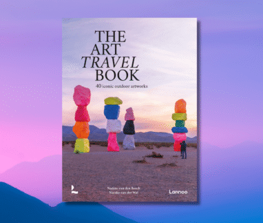 boekomslag van The Art Travel Book met kleurrijke kunstinstallatie in een woestijnlandschap