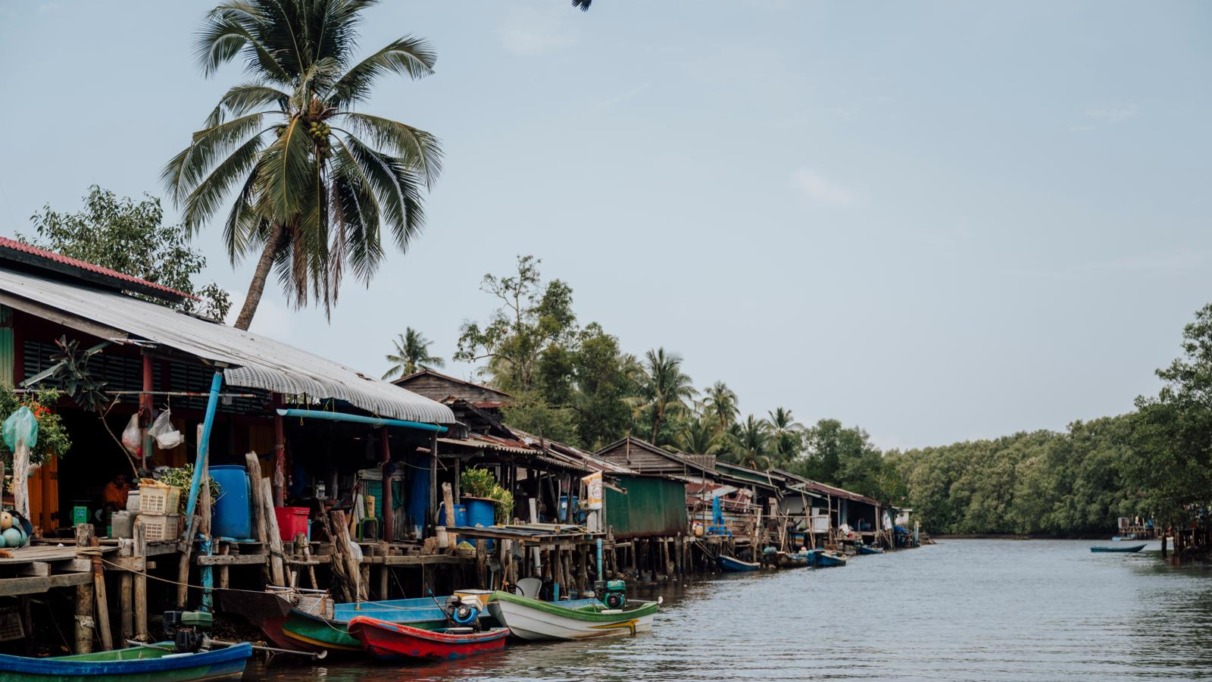 raditioneel vissersdorp met houten huizen en boten langs een waterweg in de Cardamom Mountains in Cambodja