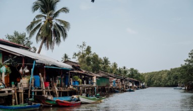 raditioneel vissersdorp met houten huizen en boten langs een waterweg in de Cardamom Mountains in Cambodja