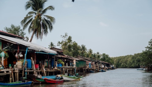 raditioneel vissersdorp met houten huizen en boten langs een waterweg in de Cardamom Mountains in Cambodja
