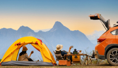 Stel geniet in tentje naast auto van het uitzicht tijdens een roadtrip
