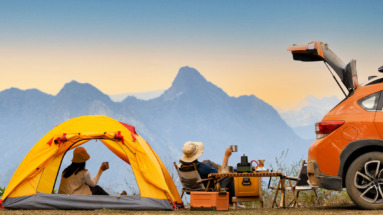 Stel geniet in tentje naast auto van het uitzicht tijdens een roadtrip