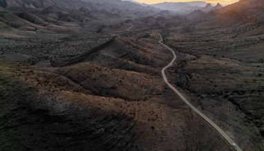Een panoramisch bovenaanzicht van de kronkelende weg door de uitgestrekte, ruige vallei van Gamkaskloof in Zuid-Afrika tijdens de zonsondergang.