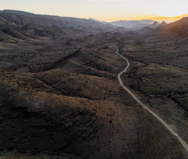 Een panoramisch bovenaanzicht van de kronkelende weg door de uitgestrekte, ruige vallei van Gamkaskloof in Zuid-Afrika tijdens de zonsondergang.