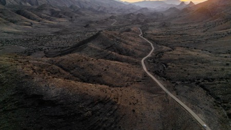 Een panoramisch bovenaanzicht van de kronkelende weg door de uitgestrekte, ruige vallei van Gamkaskloof in Zuid-Afrika tijdens de zonsondergang.