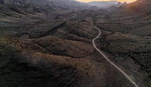 Een panoramisch bovenaanzicht van de kronkelende weg door de uitgestrekte, ruige vallei van Gamkaskloof in Zuid-Afrika tijdens de zonsondergang.
