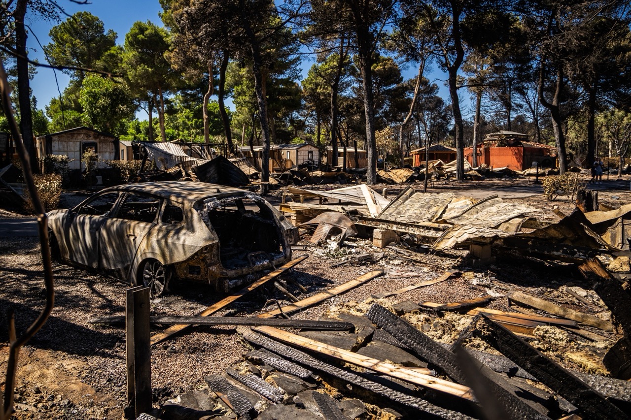 Op deze foto zijn puin en een uitgebrande auto te zien op camping ‘Le Brasilia’, een dag nadat er brand was uitgebroken, in Canet-en-Roussillon, Zuid-Frankrijk, op 3 juli 2026. Bijna 3.000 mensen moesten worden geëvacueerd uit verschillende campings, maar ook uit bedrijven en verschillende gemeenten, nadat er brand was uitgebroken in Sainte-Marie-la-Mer en zich had verspreid naar Canet-en-Roussillon, waardoor het watersportcentrum werd getroffen, zo meldden de brandweer en de prefect van de Pyrénées-Orientales op 2 juli 2026.