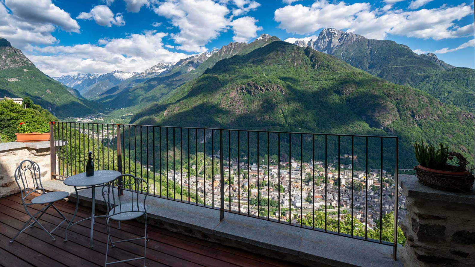 Panoramisch uitzicht over Chiavenna en de bergen van Valchiavenna vanaf een terras in Pianazzola
