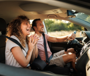 Young couple shares lighthearted moments and laughter during their adventurous car journey